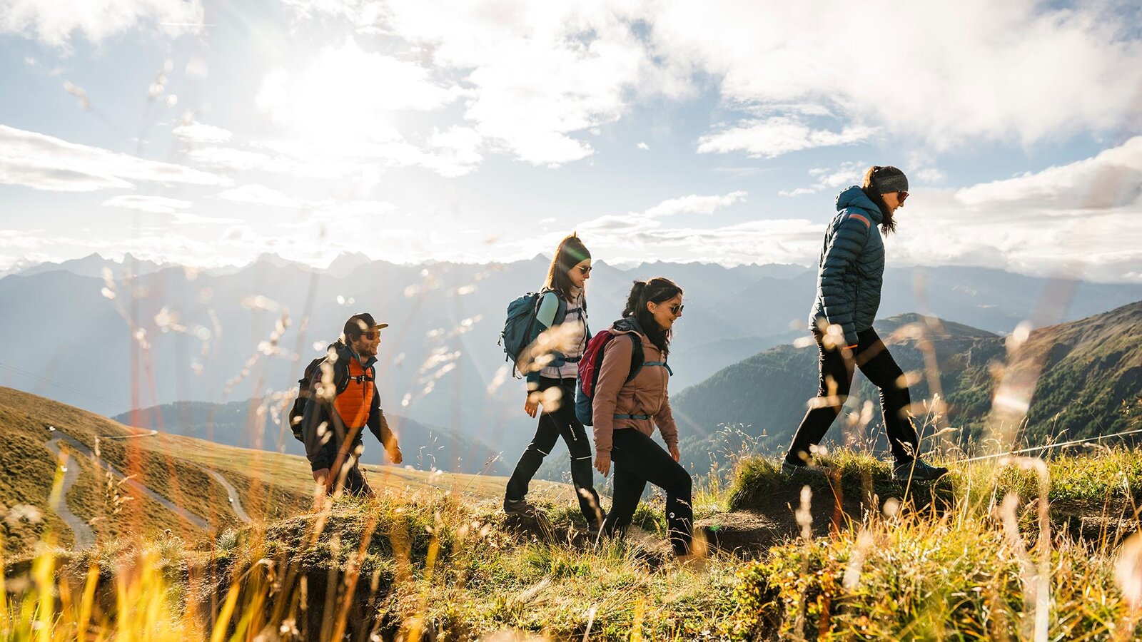 Gruppe Wanderer unterwegs auf einem Panoramaweg in den Tiroler Alpen.