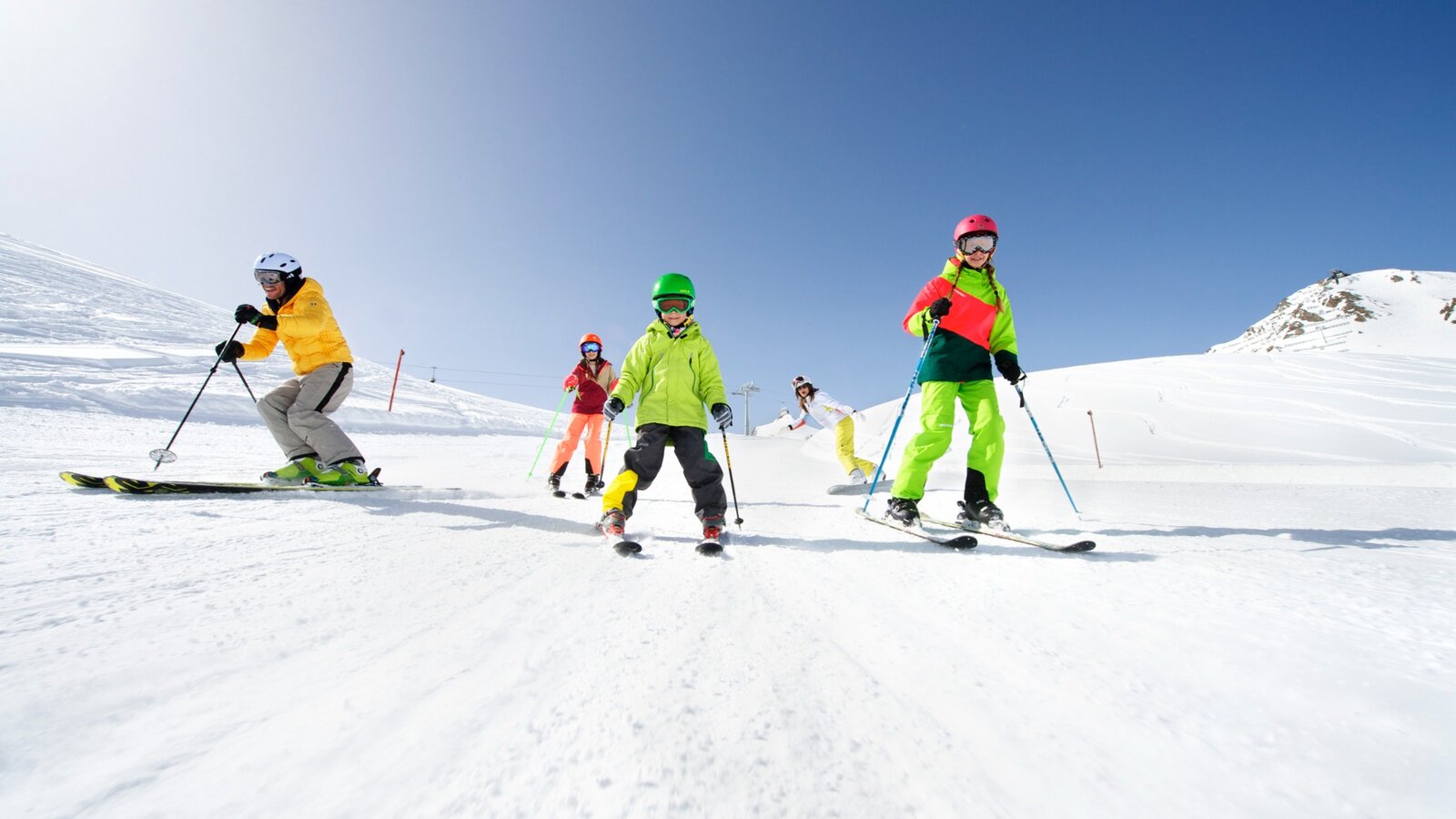 Kinder lernen Skifahren auf einer sonnigen Anfängerpiste im Skigebiet Serfaus-Fiss-Ladis in Tirol.