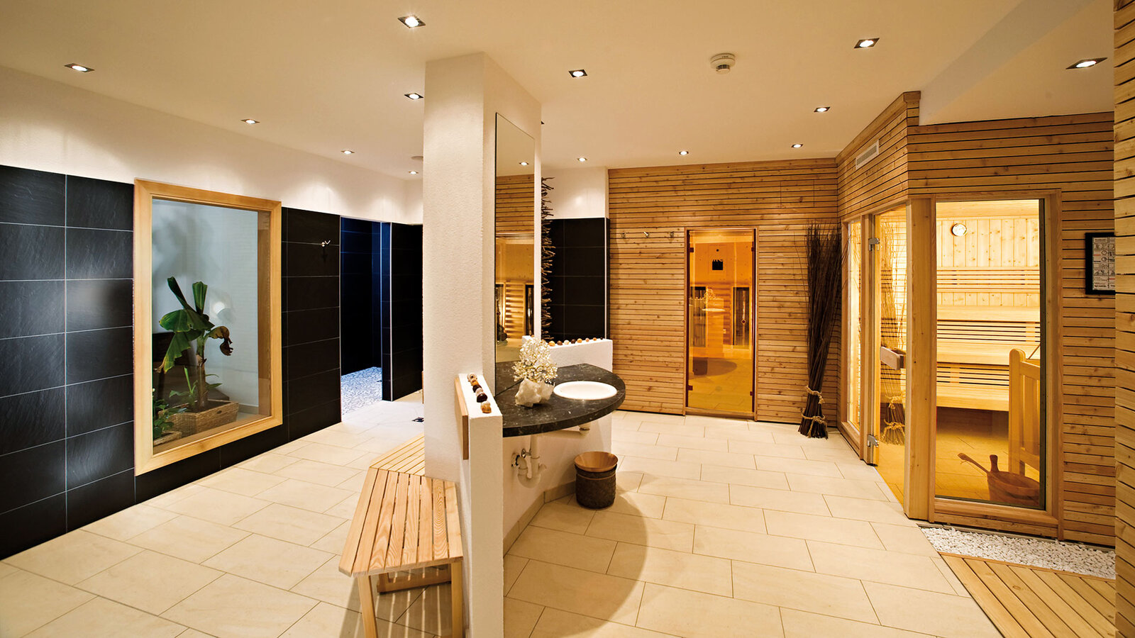 Saunabereich mit Holzsauna, Liegen und Sitzmöglichkeiten im Wellnessbereich.